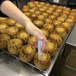 Briony injecting jelly into prepared pies